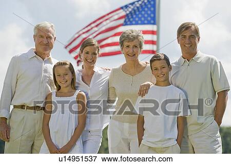 Multi-generational family posing in front of American flag View Large Photo Image Stock Photo - Multi-generational family posing in front of American flag. Fotosearch
