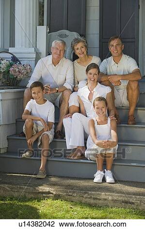 Stock Image - Multi-generational family sitting on front stoop. Fotosearch