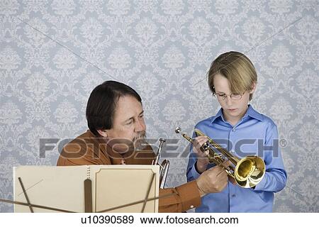 Music teacher teaching boy to play trumpet View Large Photo Image Stock Photo - Music teacher teaching boy to play trumpet. Fotosearch
