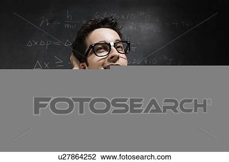 Stock Image - Nerdy man in front of blackboard. Fotosearch
