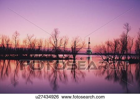 Stock Photograph - Oil platform in distance at sunset, Louisiana. Fotosearch