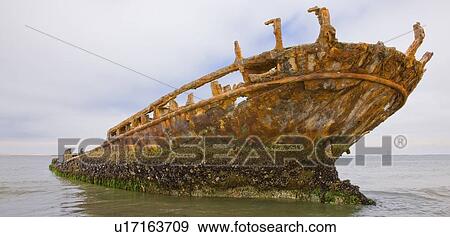 Stock Photo - Old shipwreck sticking out of water, Namibia, Africa. Fotosearch