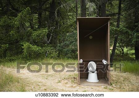 Stock Image - Outhouse in forest. Fotosearch
