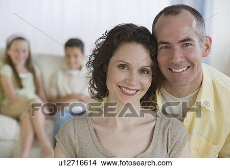 Picture - Parents with children in background. Fotosearch