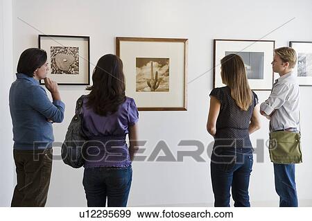 Stock Photo - People looking at pictures in art gallery. Fotosearch
