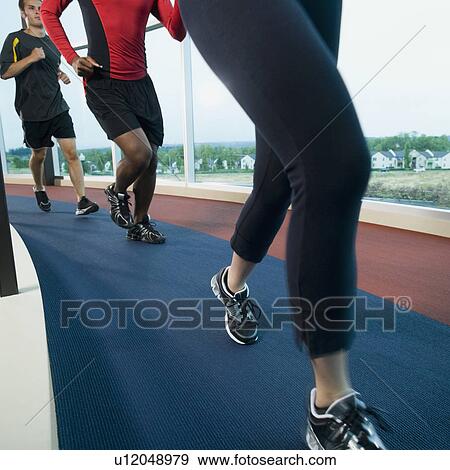 Stock Photo - People running on indoor track. Fotosearch
