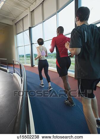 Stock Photo - People running on indoor track. Fotosearch