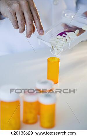 Pharmacist filling pill bottle View Large Photo Image Stock Photo - Pharmacist filling pill bottle. Fotosearch