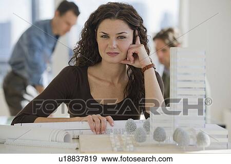 Stock Photo - Portrait of architect with blueprints and building model. Fotosearch