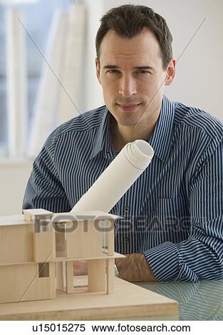 Stock Photography - Portrait of architect with blueprints and building model. Fotosearch