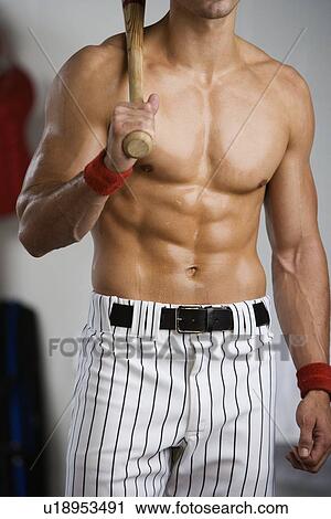 Stock Image - Portrait of baseball player with bare chest holding bat. Fotosearch
