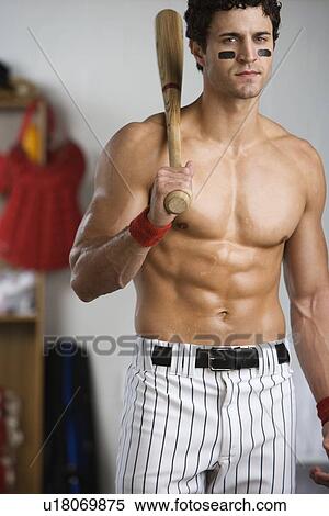 Portrait of baseball player with bare chest holding bat in locker room View Large Photo Image Stock Photography - Portrait of baseball player with bare chest holding bat in locker room. Fotosearch