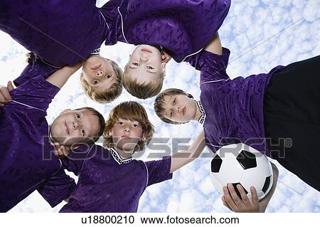 Stock Image - Portrait of boys soccer team in huddle. Fotosearch
