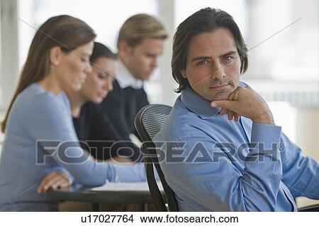 Portrait of businessman with business people in background View Large Photo Image Picture - Portrait of businessman with business people in background. Fotosearch