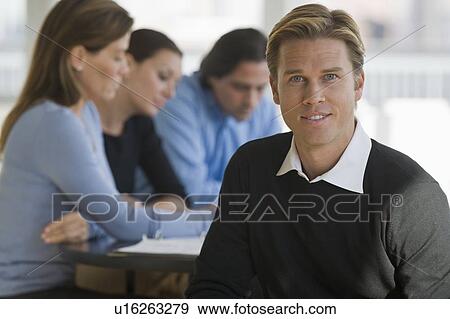 Portrait of businessman with business people in background View Large Photo Image Stock Photo - Portrait of businessman with business people in background. Fotosearch