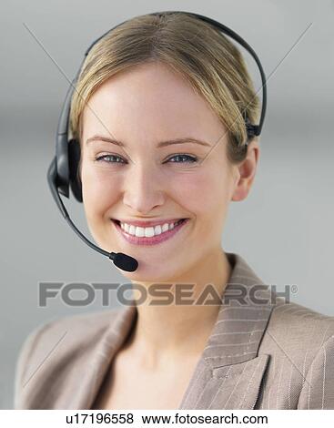 Stock Photo - Portrait of businesswoman wearing telephone headset. Fotosearch