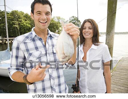 Portrait of couple holding freshly caught fish View Large Photo Image Stock Photo - Portrait of couple holding freshly caught fish. Fotosearch