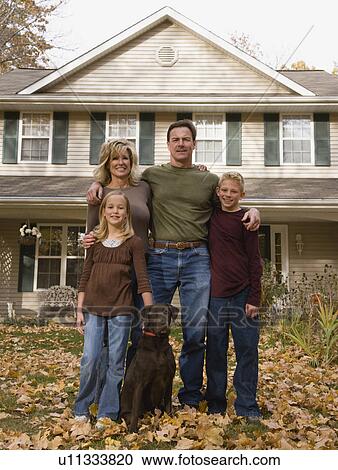 Stock Image - Portrait of family in front of house. Fotosearch