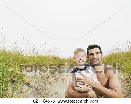 Portrait of father and son hugging on beach View Large Photo Image Stock Photography - Portrait of father and son hugging on beach. Fotosearch