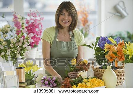 Stock Image - Portrait of florist arranging flowers. Fotosearch