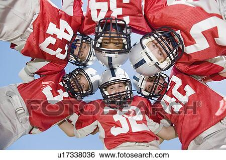 Stock Photograph - Portrait of football players in huddle. Fotosearch