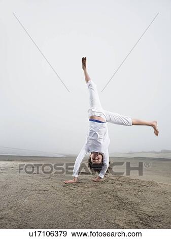 Portrait of girl doing handstand on beach View Large Photo Image Stock Photo - Portrait of girl doing handstand on beach. Fotosearch