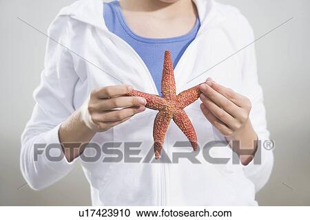 Stock Image - Portrait of girl holding starfish. Fotosearch