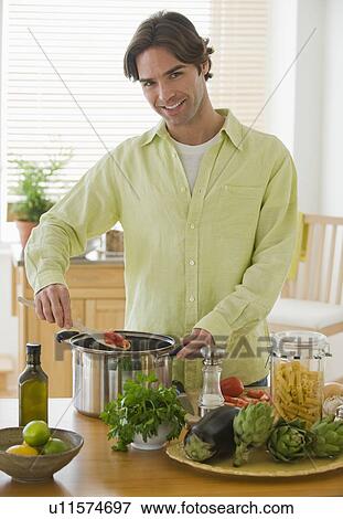 Portrait of man preparing meal in kitchen View Large Photo Image Stock Photo - Portrait of man preparing meal in kitchen. Fotosearch