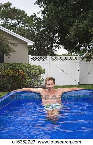 Portrait of man soaking in inflatable swimming pool View Large Photo Image Stock Photo - Portrait of man soaking in inflatable swimming pool. Fotosearch