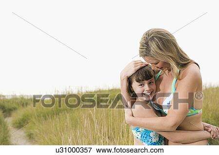 Portrait of mother hugging daughter on beach View Large Photo Image Stock Photo - Portrait of mother hugging daughter on beach. Fotosearch