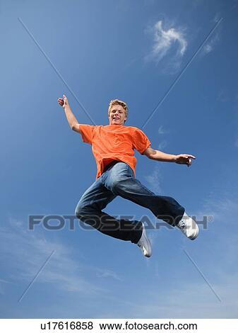 Stock Photo - Portrait of teenage boy in mid-air. Fotosearch