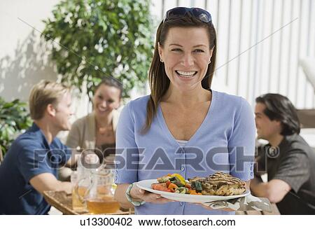 Portrait of woman dining on patio with friends View Large Photo Image Stock Image - Portrait of woman dining on patio with friends. Fotosearch