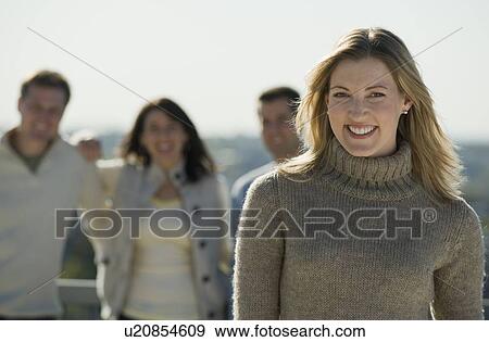 Portrait of woman with friends in background View Large Photo Image Stock Photo - Portrait of woman with friends in background. Fotosearch