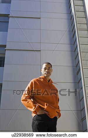 Portrait of young man standing in front of highrise View Large Photo Image Stock Photo - Portrait of young man standing in front of highrise. Fotosearch