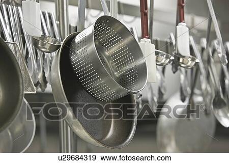 Pots and cooking utensils hanging from rack View Large Photo Image Stock Photo - Pots and cooking utensils hanging from rack. Fotosearch