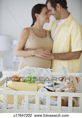 Pregnant Hispanic couple hugging View Large Photo Image Stock Image - Pregnant Hispanic couple hugging. Fotosearch