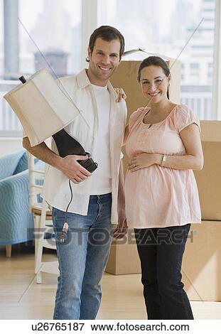 Pregnant Hispanic couple in new house View Large Photo Image Stock Photo - Pregnant Hispanic couple in new house. Fotosearch