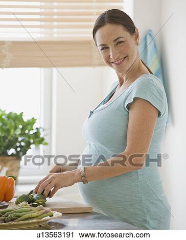 Pregnant Hispanic woman chopping vegetables View Large Photo Image Stock Image - Pregnant Hispanic woman chopping vegetables. Fotosearch