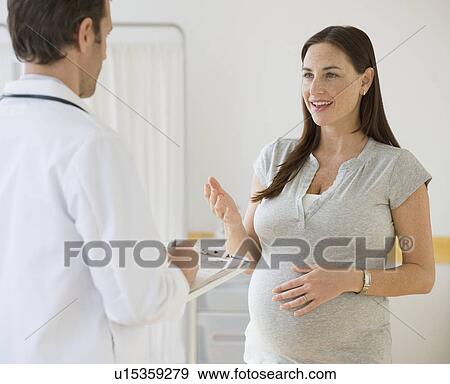 Stock Photo - Pregnant woman talking to doctor. Fotosearch