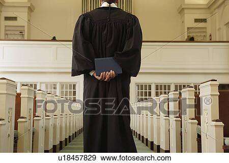 Priest holding bible behind back View Large Photo Image Stock Photo - Priest holding bible behind back. Fotosearch