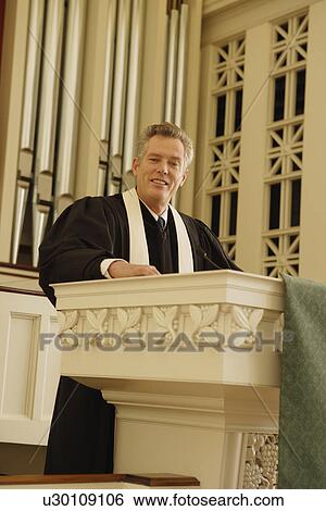 Priest standing at pulpit View Large Photo Image Stock Photograph - Priest standing at pulpit. Fotosearch