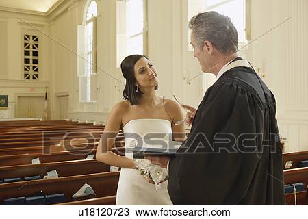 Stock Image - Priest talking to bride. Fotosearch