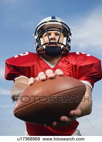 Quarterback holding football View Large Photo Image Stock Photo - Quarterback holding football. Fotosearch