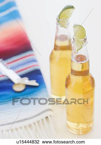 Refreshing beer bottles garnished with lime slices View Large Photo Image Stock Image - Refreshing beer bottles garnished with lime slices. Fotosearch