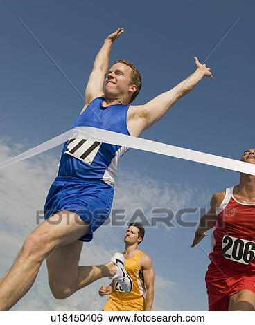 Stock Photograph - Runner breaking through finish line. Fotosearch