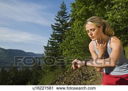 Stock Image - Runner checking heart rate. Fotosearch