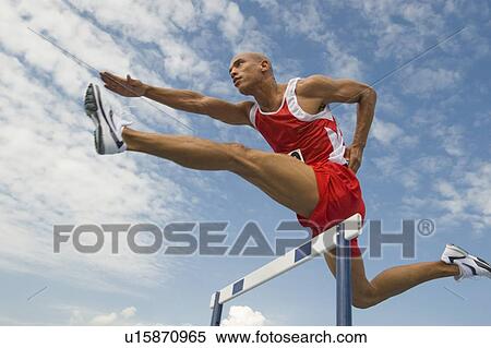 Stock Photography - Runner jumping over hurdle. Fotosearch