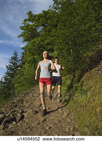 Stock Image - Runners descending rocky trail. Fotosearch