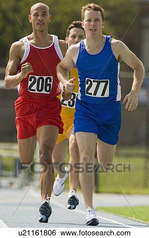 Runners racing on track View Large Photo Image Stock Photograph - Runners racing on track. Fotosearch