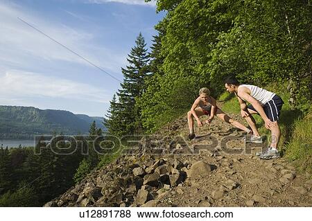 Stock Photo - Runners stretching on rocky trail. Fotosearch